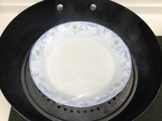 5、火龙果麻薯面包,趁面团发酵时，来制作下麻薯。除黄油以外的麻薯材料混合拌匀，上沸腾的锅中蒸熟10分，表面凝固且无液体即可。