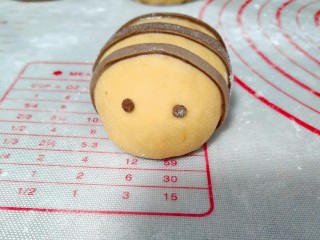 13、宝宝最爱的小蜜蜂豆包,用巧克力面团团两个小球球，按到豆包上。