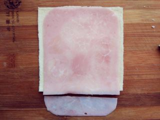 6、快手棒棒糖三明治,将火腿片放在上面，切成合适大小