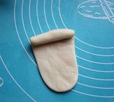 6、 荷花酥,擀成椭圆形，再至上而下卷起。