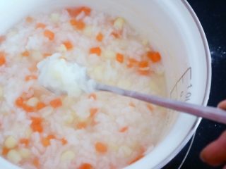 12、宝宝辅食之玉米胡萝卜粥,粥变得粘稠了，水份也明显减少了，米粒也都打开了这样就差不多好了，在熬几分钟就可以了