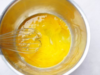 3、酥脆软滑的蛋奶吐司布丁,将2个鸡蛋打入碗中。