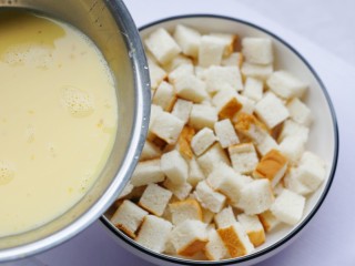 6、酥脆软滑的蛋奶吐司布丁,将蛋奶液倒入面包丁中，先倒入少许，