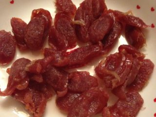 2、紫薯粥,把香肠斜切一段段的。放入锅内蒸。蒸5分钟就差不多了。