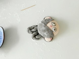 12、小嫦娥花样馒头,在粘上一层黑面片，然后再印堂处，粘上红色圆面片。