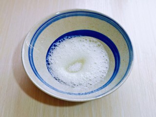 11、无油低脂～奶香松饼,启动电动打蛋器将蛋白低速打至呈现鱼眼泡，加入三分一的细砂糖，继续保持低速。