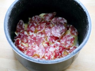 4、香肠土豆焖饭,7.将香肠片平铺在土豆块上。