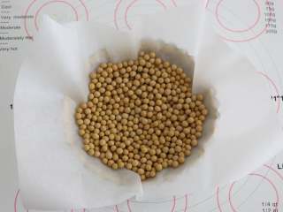 11、南瓜派,派皮上铺一张油纸,放上一些豆子压着,以防烤制过程中派皮鼓起。