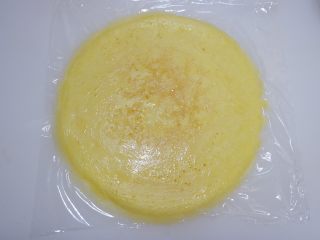 13、赤豆糯米蛋卷,案板上铺一张保鲜膜，将煎好的蛋饼放在上面。