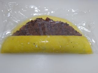 15、赤豆糯米蛋卷,用保鲜膜协助卷起来。