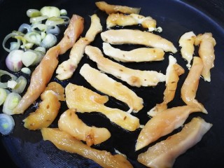 14、孜然鸡胸肉,把煎软的圆葱推到锅边，逐条放上鸡胸肉。