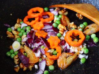 8、核桃仁虾干时蔬蛋炒饭,加入胡萝卜继续翻炒均匀。