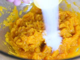 3、只需一根牙签，新手也能做出以假乱真的漂亮，黄金南瓜包,将蒸熟的南瓜，倒入碗中，搅拌成泥后倒入15g糖，再次搅拌​