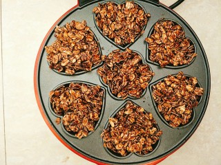 9、燕麦饼干,小红锅预热好以后把混合好的燕麦片用勺子倒入烤盘