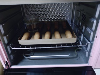 15、吃一次就会爱上它的美～可可酸奶面包,放入烤箱中进行二次发酵，在烤盘中间放一杯开水，保持面团湿度！