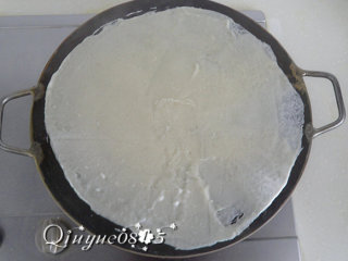 6、地方菜　煎饼,舀一勺面糊，用竹刮板或竹蜻蜓把面糊抹开