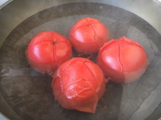 1、美味早餐 番茄鸡蛋牛肉手擀面,番茄洗干净，用刀划个“十”字，用开水烫一烫番茄，然后撕去番茄的皮。