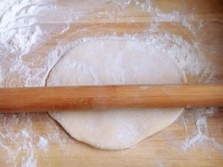 22、美味早餐 番茄鸡蛋牛肉手擀面,面被擀的薄了些，但是还不太理想，再撒上面粉，用擀面杖卷起面饼继续再擀。