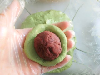 16、豆沙青团,取40克面团,揉圆按扁,放入豆沙馅