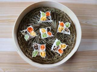 8、四喜蒸饺,四个花瓣里分别放上香菇、胡萝卜、芹菜、鸡蛋，一一放进蒸笼；