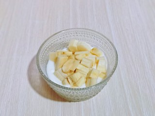 2、快手早餐～香蕉酸奶三明治,首先将酸奶倒入器具中，香蕉去皮，切小块加入酸奶中，用小勺拌均匀，放旁边备用。(香蕉块切的小一点)
