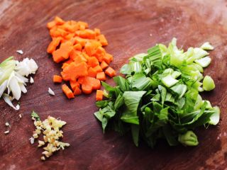 5、生滚猪肝时蔬小米粥,小油菜摘洗干净后,用刀切碎,葱姜切碎,胡萝卜切小丁备用。