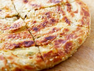 10、咸蛋芝麻葱油酥饼,13.放在案板上切块食用。