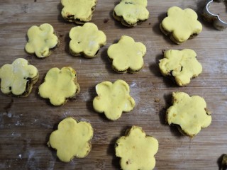 18、南瓜糯米夹心饼,按压后，脱模成，小个的花朵夹心饼坯，当中点上黑芝麻