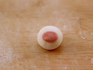 11、萌猪黑芝麻汤圆,把馅料包入以后、取一点粉色面团揉成长圆形、蘸点水粘在白色面团上做鼻子
