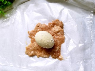 4、苏格兰蛋,再将肉糜铺上，（有刷清水，肉糜不会沾在保鲜袋上）把鸡蛋放在肉糜上方