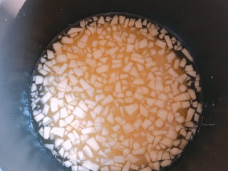 3、苹果小米粥,把小粒的苹果加入到电饭锅中。并加入适量清水，然后选择煮粥键