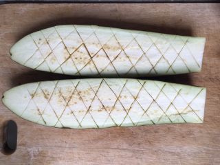 6、蒜香烤茄子,茄子对半切开，斜刀切，但是不要切断，跟切鱿鱼花一样的手法