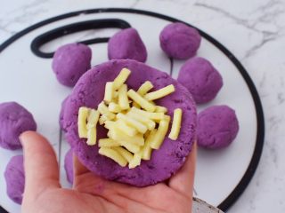 12、紫薯芝士饼,取一份面团按扁放入芝士碎