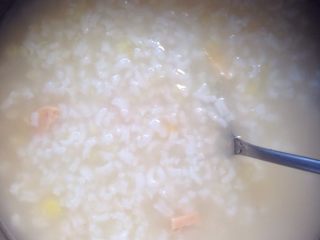 3、土豆泥玉米肠粥（1人份）,快好时，加入调好味道的土豆泥。混合均匀边搅拌边熬煮1到2分钟。关火，加少许盐巴搅拌均匀。粥有点点粉红是因为番茄酱哟。