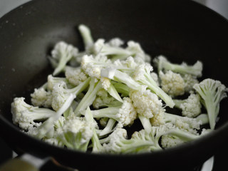 4、干煸菜花,锅里再次倒入少许油，烧热后放入菜花煸炒