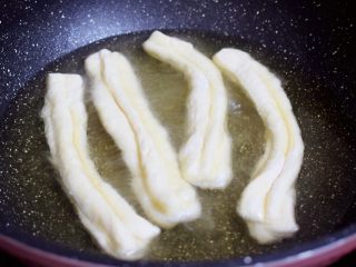 10、自制健康油条,锅中倒入适量的食用油，待油温7-8成热时，放入油条生胚
