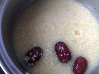 9、鸡蛋小米粥,把炖好的小米粥倒入另一个小锅里，加入红枣继续煮。