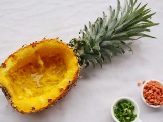 1、色彩缤纷的菠萝炒饭,菠萝切成碗状，挖去果肉。盐水泡20分钟。