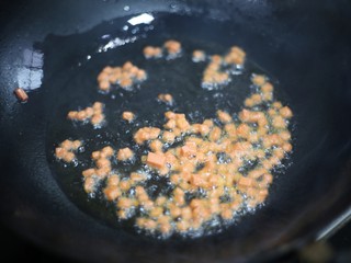 6、色彩缤纷的菠萝炒饭,热锅热油，加入火腿爆香。