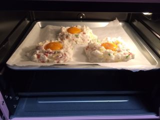 9、溏心云朵鸡蛋,送入烤箱中层，约170度烤5分钟。然后取出，将蛋黄勺入凹形处，并撒上少许盐和黑胡椒粉，再次送入烤箱中烤3分钟即可