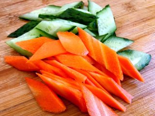 10、木须肉,依次把黄瓜胡萝卜都切成比较薄的片