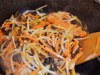12、鱼香肉丝,放入胡萝卜丝、木耳丝和洋葱丝翻炒至食材变软。
