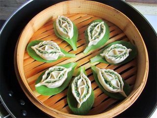 13、鸳鸯蒸饺 ,把蒸饺放在菜叶上摆好，注意每个之间留点空隙，盖上笼盖，先大火将水煮开，然后中火蒸15分钟即可