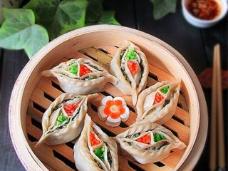 14、鸳鸯蒸饺 ,蒸好的饺子，蒸熟后要趁热立即把菜叶取下来，接下来为了好看你可以在饺子中心两个坑里分别洒上胡萝卜碎和蒜碎或香菜
