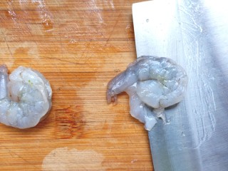 2、虾仁蔬菜煎蛋饼,把虾仁从中间切开