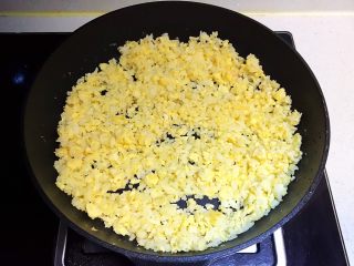 15、蚕豆火腿肠炒饭,翻炒均匀，让每粒米饭都能均匀的裹上鸡蛋液，而且是米饭粒粒松散，颗颗金黄