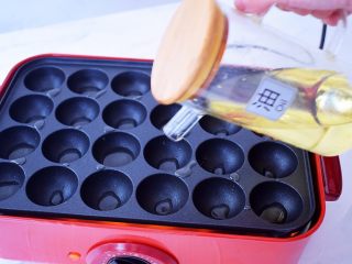 8、章鱼小丸子,美食锅放入章鱼丸子盘，启动美食锅开高温预热，预热好再倒入食用油