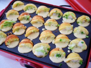 13、章鱼小丸子,转低温然后用筷子或竹签把丸子整理一下，将外面多余的面糊整理进去，再转动丸子至一半时再倒入面糊，如图，这样更能保证煎出来的丸子圆润