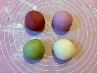 2、多彩绣球豆沙包,把面团平均分成4份，取三团分别揉进抹茶粉、红曲粉和紫薯粉。