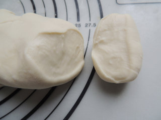 7、卡通小猪馒头,少量多次加入干面粉，不断按揉排气，将干面粉揉进面团里面，直到切开面团，截面细腻光滑，看不见气泡就可以了。